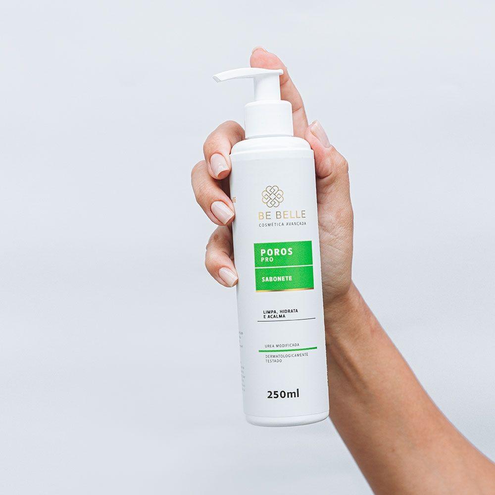Mão segurando o frasco do sabonete hidratante facial Poros
